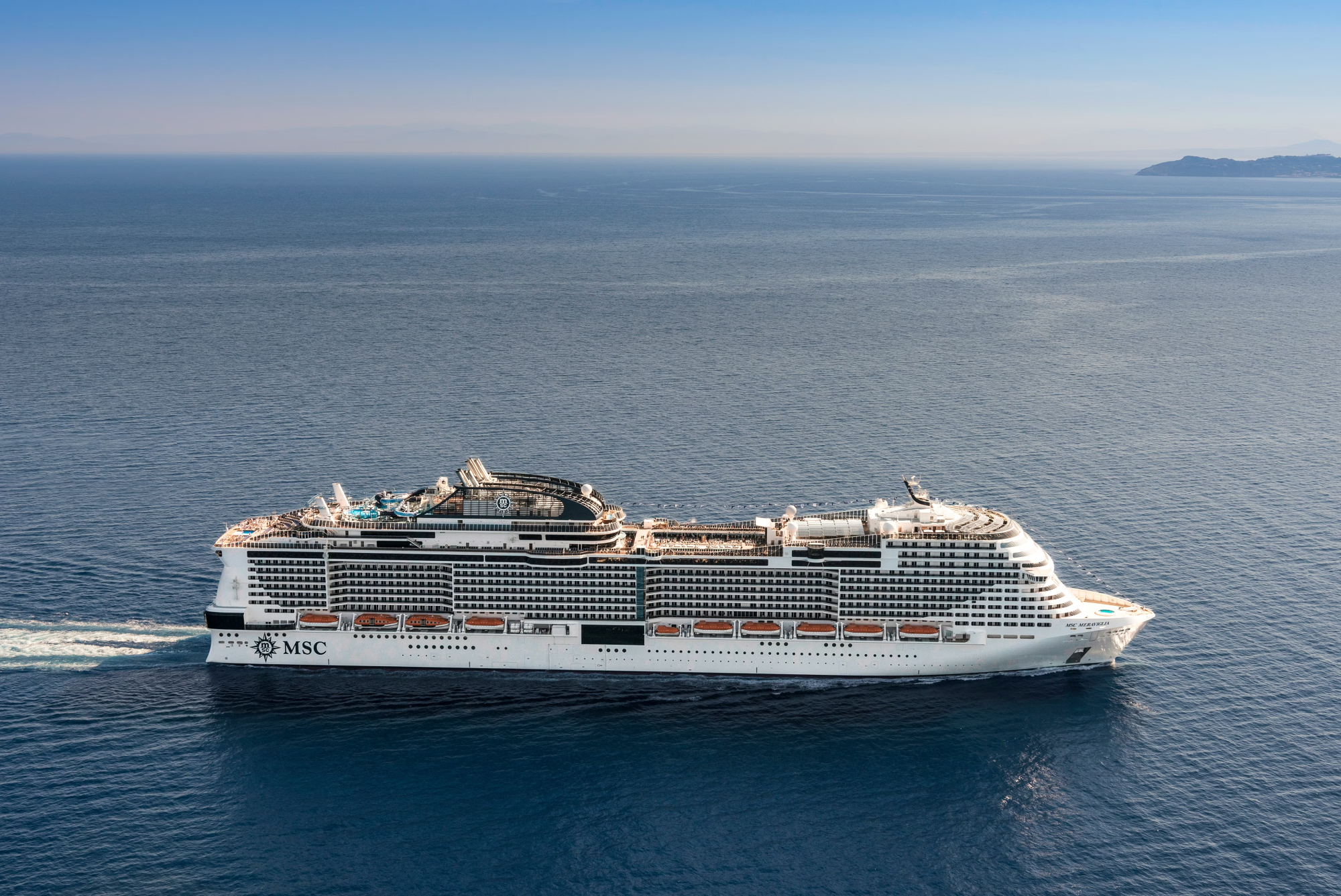 MSC Meraviglia Cruise Ship at Sea A large modern cruise ship operated by MSC Cruises sailing through calm blue waters. The white