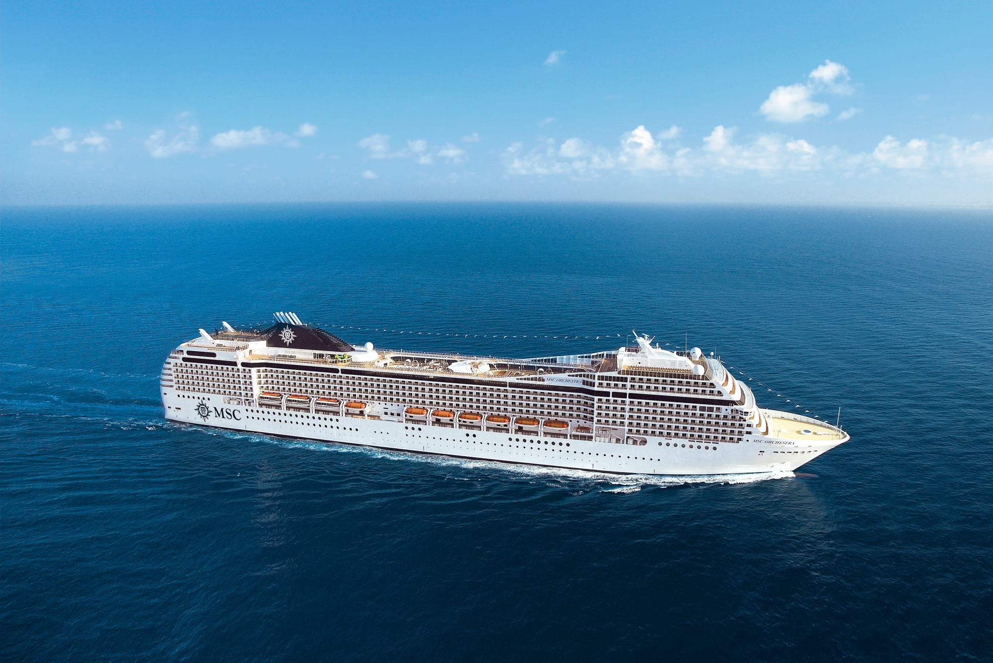 MSC Orchestra Cruise Ship at Sea A large modern cruise ship operated by MSC Cruises, captured sailing on open ocean under clear blue