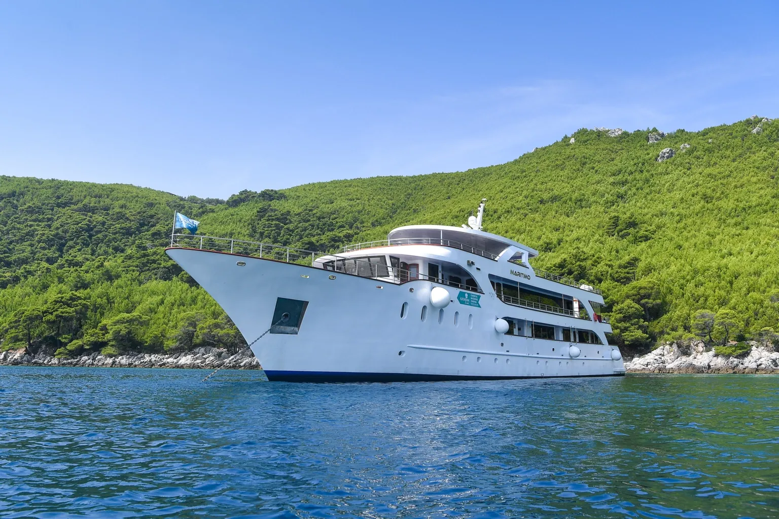 Maritimo Expedition Vessel in Adriatic Waters A white luxury expedition cruise ship named Maritimo anchored in clear blue waters surrounded
