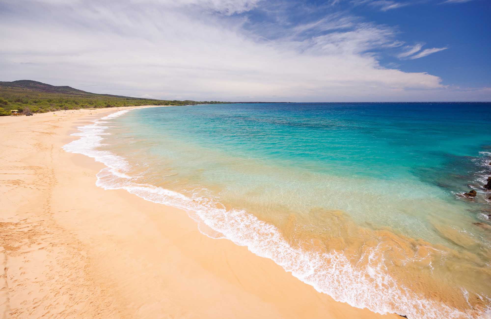 Maui Beach with Turquoise Waters and Green Slopes A pristine sandy beach in Maui, Hawaii, with crystal-clear turquoise waters, gentle white-capped