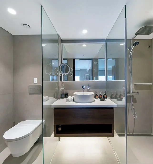 A contemporary bathroom featuring a sleek white vessel sink on a dark wood vanity, framed by
