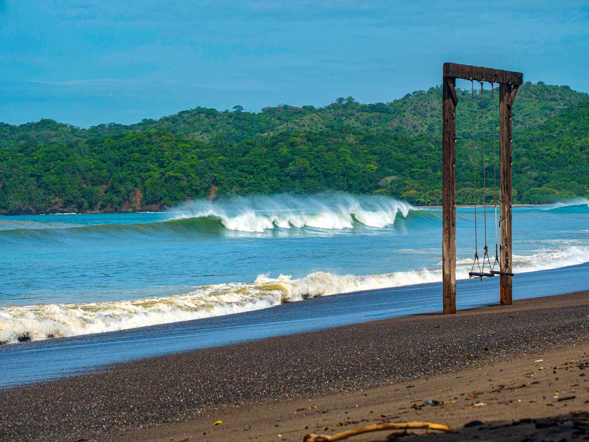 Playa Venao Surf Beach with Swing, Panama A picturesque tropical beach scene at Playa Venao in Panama, featuring perfect offshore breaking