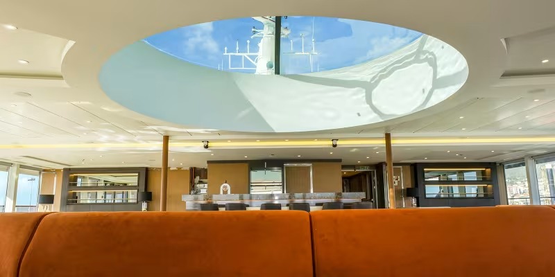 Quark Expeditions Panorama Lounge with Arctic Views A modern panorama lounge aboard a Quark Expeditions vessel, featuring expansive curved skylights