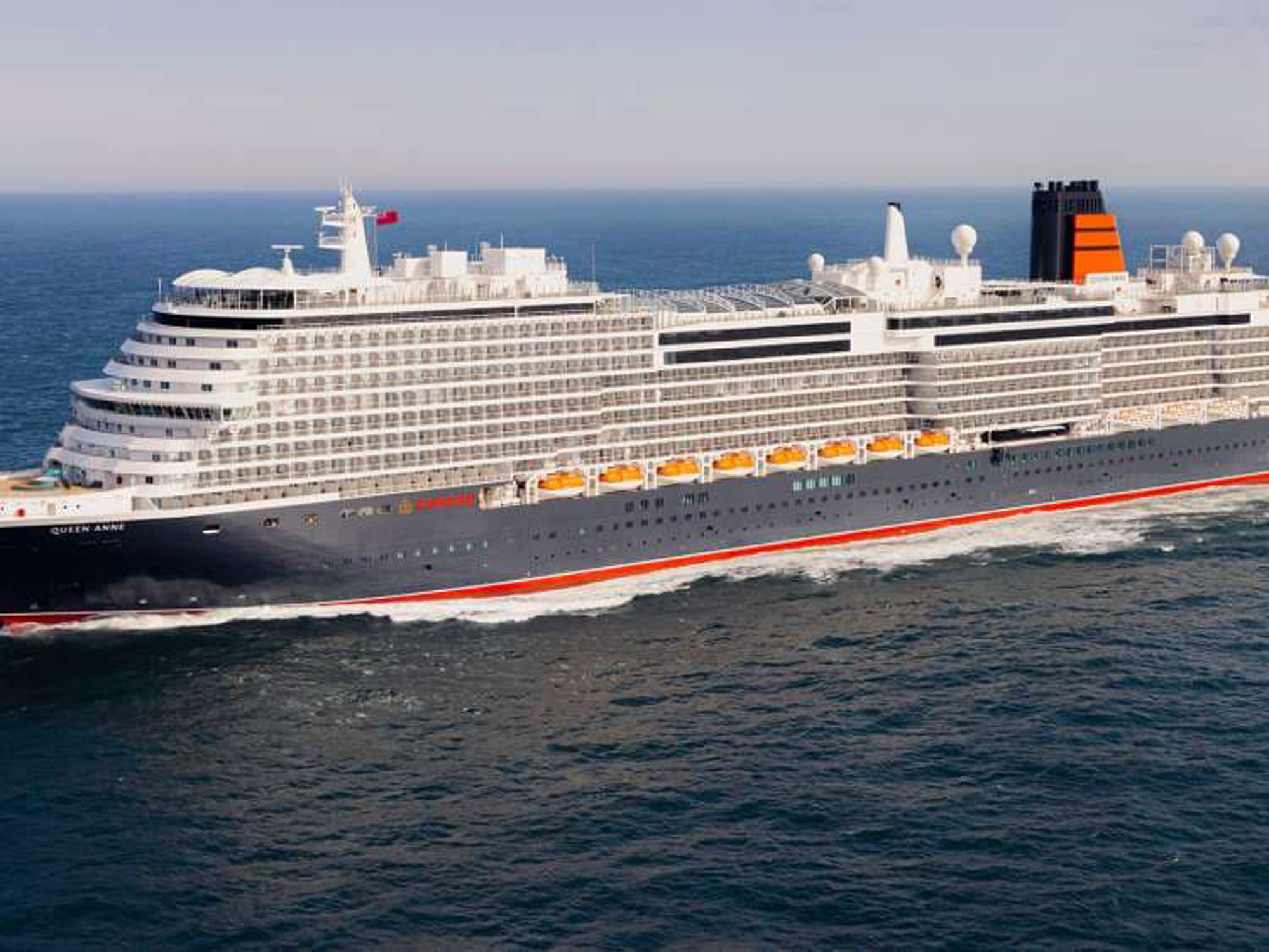 Queen Anne Cruise Ship at Sea A large modern cruise ship identified as Queen Anne sailing on open ocean waters. The vessel