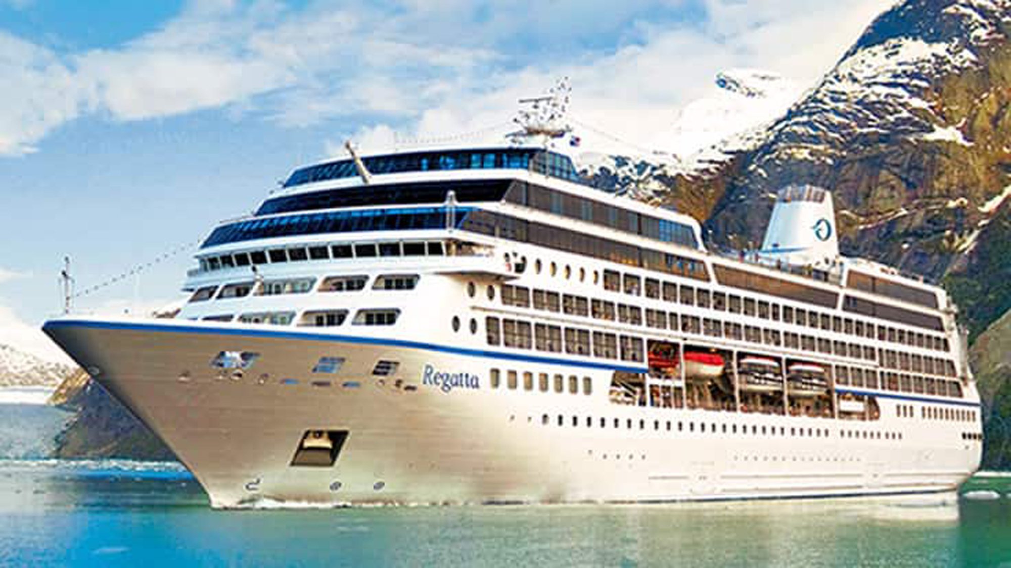 Regatta Cruise Ship in Alaska Fjord The Regatta, a luxury cruise ship with distinctive blue and white hull, is anchored in a pristine