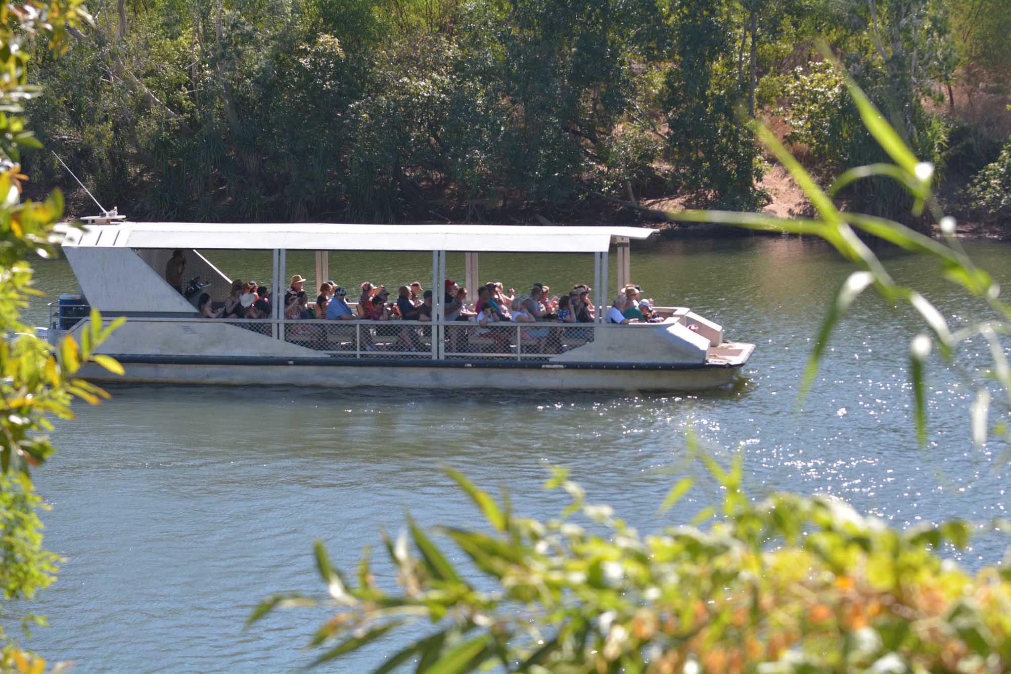 Riverboat Cruise on Katherine River, Northern Territory A scenic riverboat with passengers cruising along the Katherine River in Nitmiluk National Park