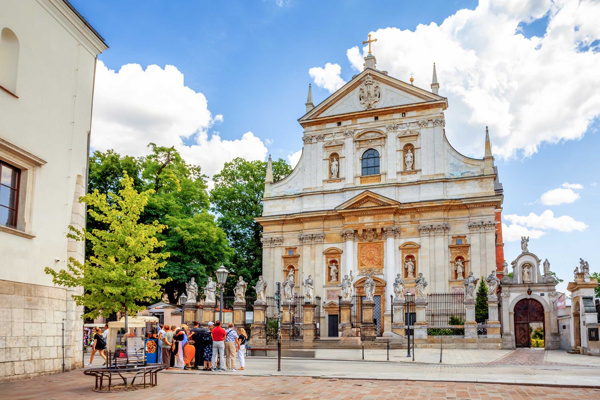 A stunning baroque church facade in Kraków's old town square, featuring ornate white and terracotta