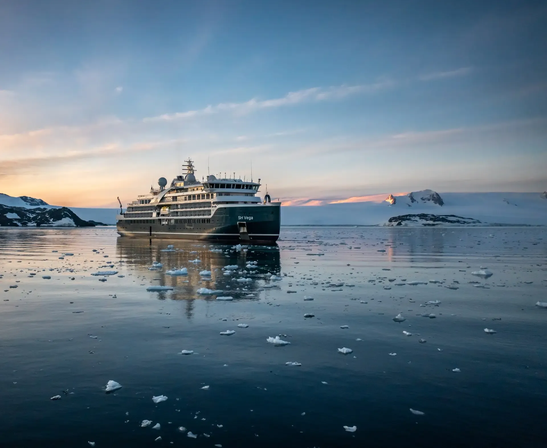 Seabourn Venture in Antarctic Waters at Sunset A luxury expedition cruise ship navigates through icy Antarctic waters at golden hour, surrounded