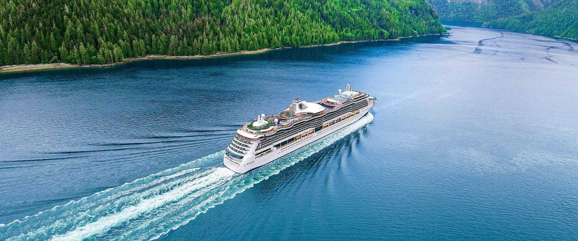 Serenade of the Seas Cruising Through Alaskan Fjord An aerial view of the Serenade of the Seas cruise ship navigating through a pristine Alaskan fjord