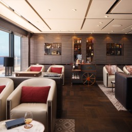 The Ritz-Carlton Yacht Collection Onboard Humidor Lounge An elegant and sophisticated onboard lounge aboard a luxury yacht, featuring rich wooden paneling