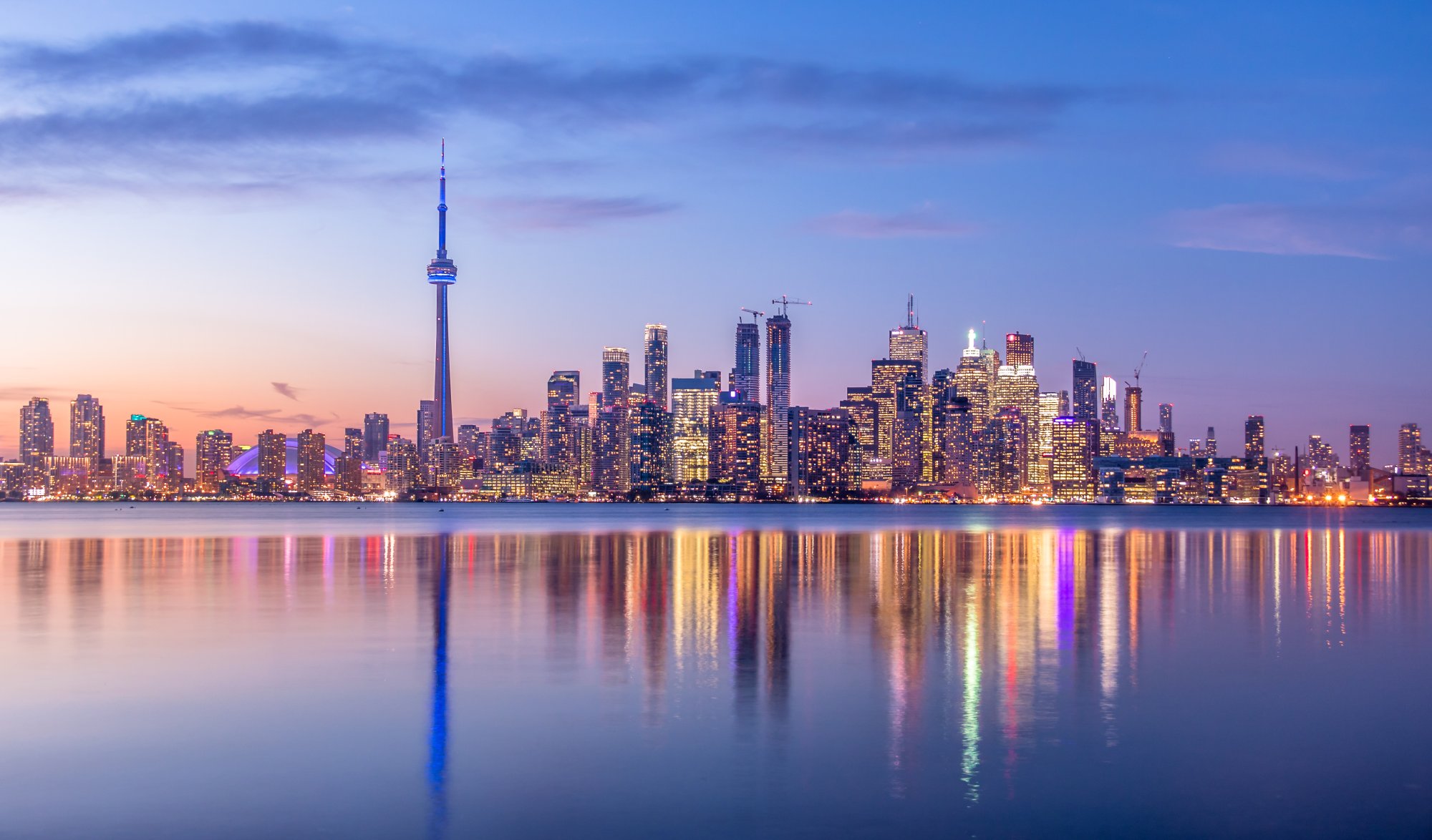 Toronto Skyline at Twilight with CN Tower A stunning twilight cityscape of Toronto's downtown skyline reflected in calm waters, featuring