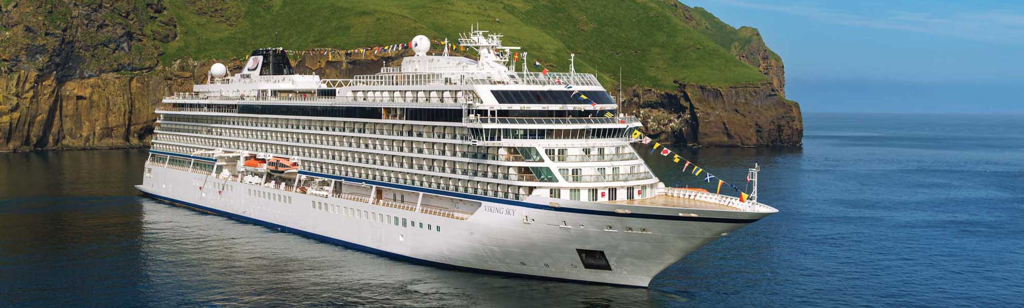 Viking Sky Cruise Ship in Norwegian Fjord The Viking Sky, a modern luxury cruise ship, is anchored in a dramatic Norwegian fjord surrounded