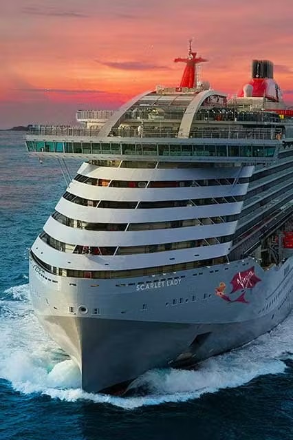 Virgin Voyages Scarlet Lady at Sunset The Virgin Voyages cruise ship Scarlet Lady is captured at sea during golden hour, with