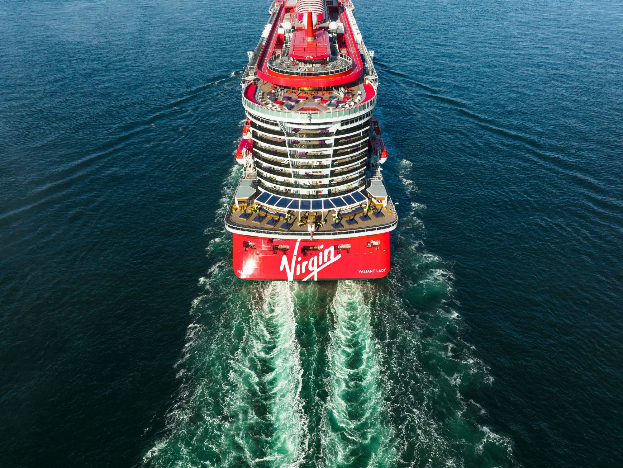 Virgin Voyages Valiant Lady Aerial Drone Shot An aerial drone photograph of the Virgin Voyages cruise ship Valiant Lady moving through calm