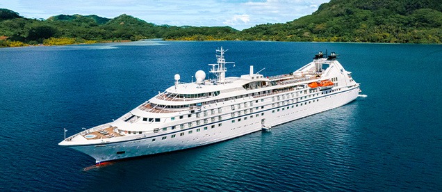 Windstar Cruises Star Breeze Luxury Yacht A sleek all-white luxury cruise yacht, the Star Breeze, anchored in clear turquoise waters
