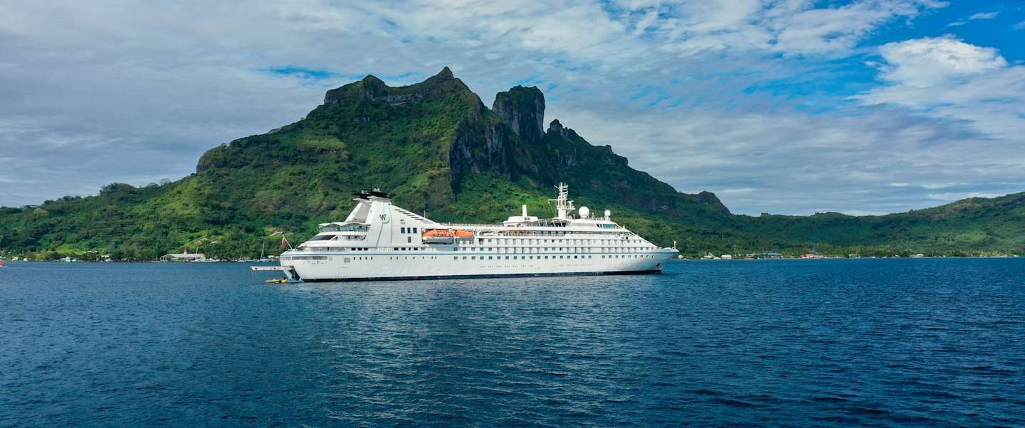 Windstar Cruises Star Breeze in Tahitian Waters The elegant Star Breeze cruise ship anchors in clear turquoise waters off a lush, mountainous