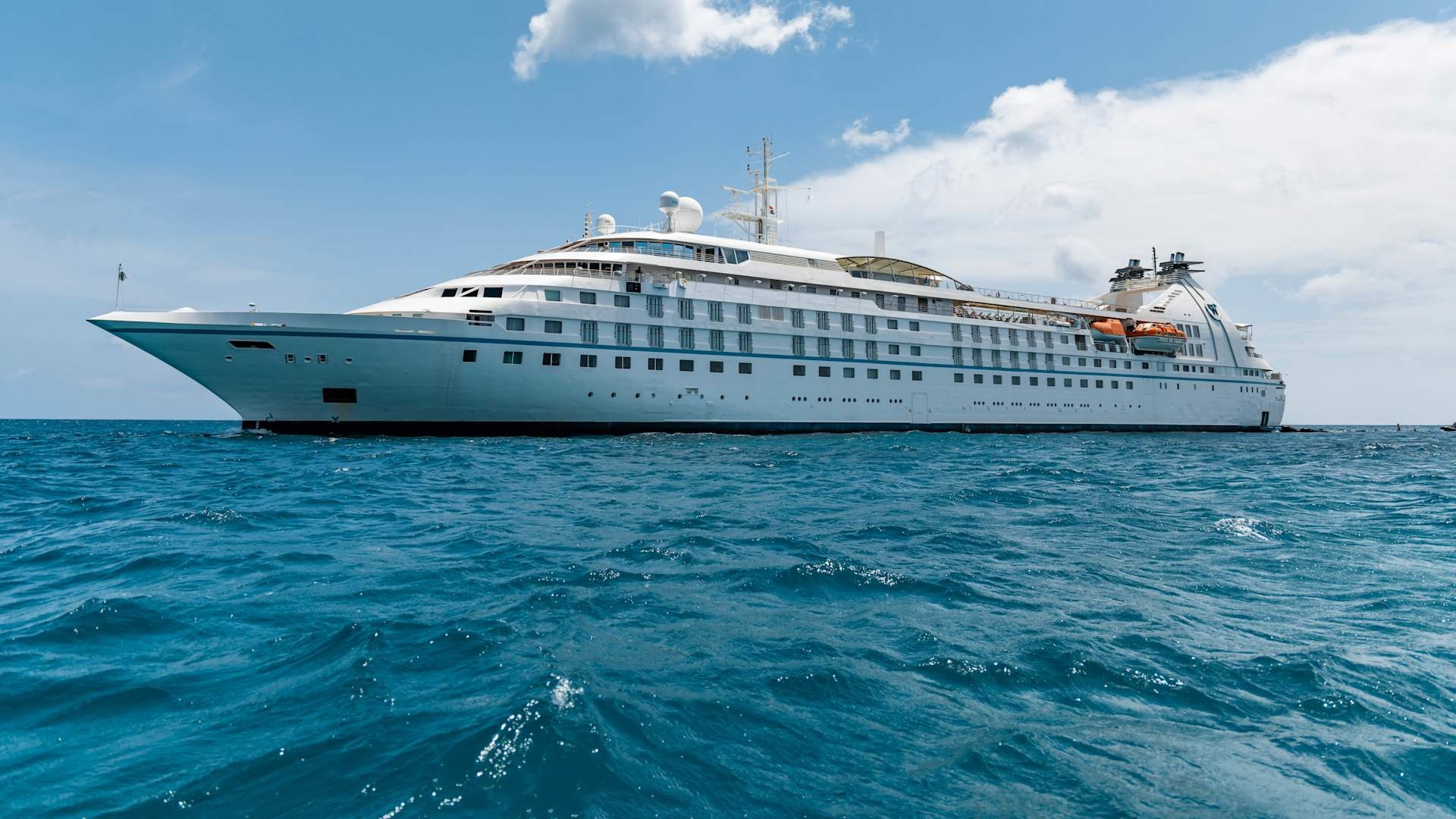 Windstar Cruises Star Legend in Caribbean Waters A luxurious small-ship cruise vessel, the Star Legend, anchored in calm turquoise Caribbean waters