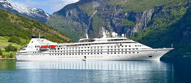 Windstar Cruises Star Legend in Norwegian Fjord A luxury small-ship cruise vessel, the Star Legend, navigates through a dramatic Norwegian fjord