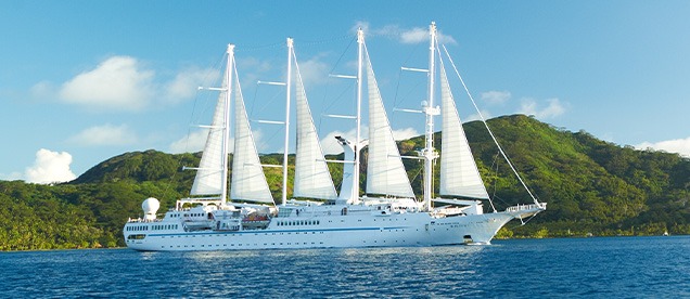 Windstar Cruises Wind Spirit Sailing Yacht A luxurious white sailing yacht with four full masts under full sail on turquoise tropical waters