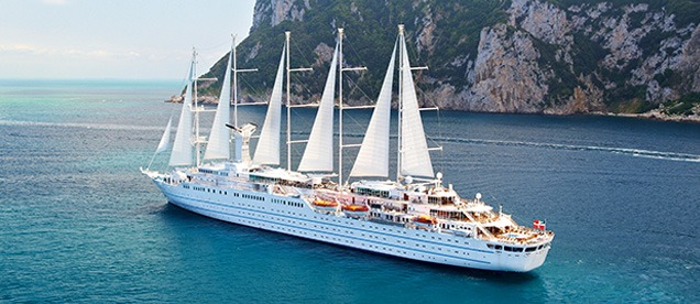 Windstar Cruises Yacht Wind Surf at Sea A luxurious white sailing yacht with multiple masts anchored in turquoise Mediterranean waters near