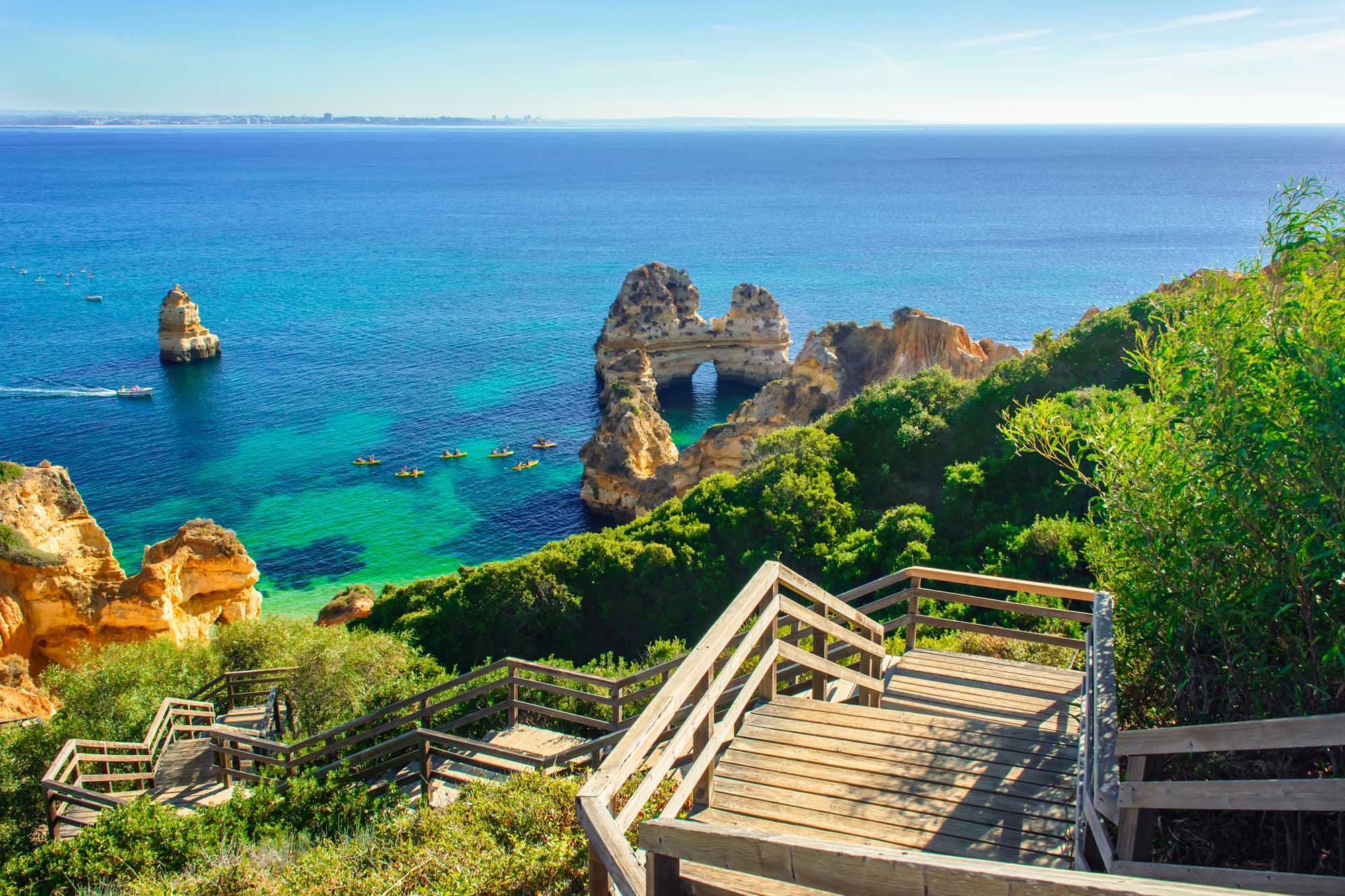 Wooden Steps to Ponta da Piedade Beach, Lagos A scenic wooden boardwalk descends toward turquoise waters and dramatic golden rock formations